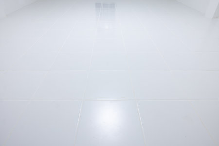 White tile floor with grid line of square texture pattern in perspective at night. Clean shiny of ceramic surface. Modern interior home design. Empty space for background.の写真素材