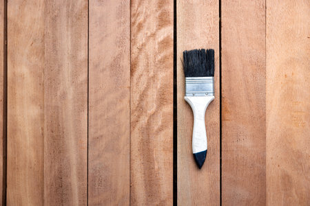 Paint brush place on pile of lumber, wood product in top view. Construction material and tool for improve, protective or coating stain grain surface. Include empty space.の写真素材