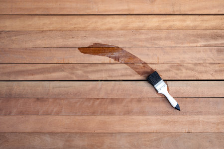 Paint brush applying wood varnish on a pile of lumber in top view. To improve protective or coating stain grain surface. Include empty space suit for concept, background.の写真素材