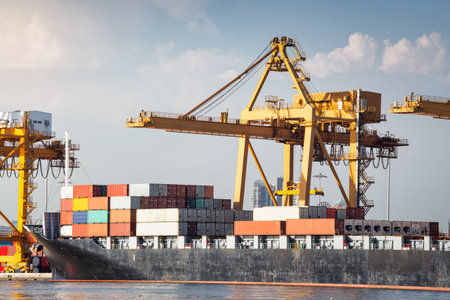 Large crane and cargo ship transport cargo container and docked at port in Bangkok of Thailand. Business industry of shipping, logistics, international global trade, import export.の写真素材