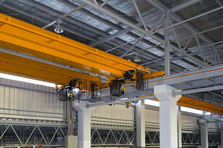Overhead crane inside factory or warehouse building. Industrial machine or lifting equipment consist...