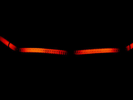 Spiral light bulbs in darkness. Red on black. Macrophotography.の写真素材