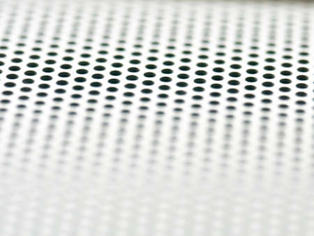 Abstract white background. Black holes. The grating sound of the speaker. Macro. Close up.の写真素材