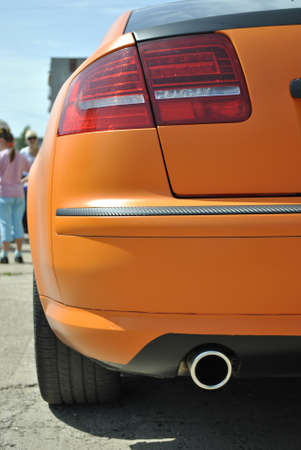 Orange car rear view. Taillight. Exhaust pipe. Summer.の写真素材