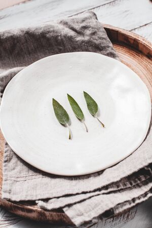 Minimalistic stock photo of sage leaves on white plate stock photoの写真素材