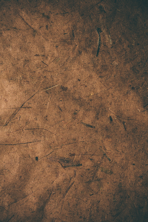 Brown rough vintage paper. Abstract background and texture for designers. Old vintage recycled paper. Dark rough vintage paper background. Brown rough paper in vintage style.の写真素材