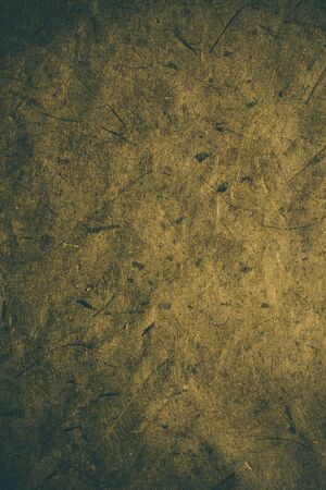 Yellow rough vintage paper. Abstract background and texture for designers. Old vintage recycled paper. Dark rough vintage paper background. Yellow rough paper in vintage style.の写真素材