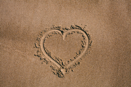 Heart drawn in the sand. Beach background with heart drawing. Heart shape love symbol as background....