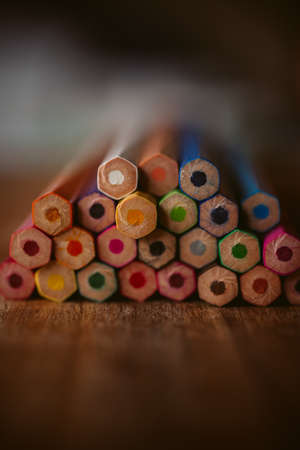 Colored pencils on wooden background with selective focus. Back to school and education concept. Crayons background for designの写真素材