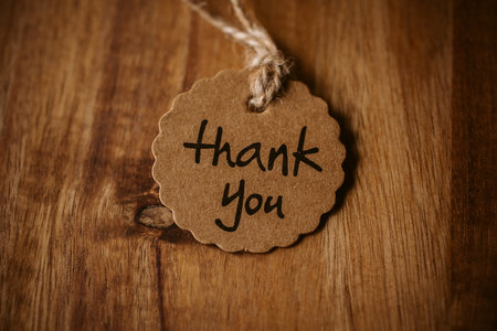 Thank you word written in a card on wooden background with selective focus. Love and gratitude...