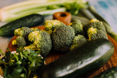 Green vegetables background with broccoli, cucumber, courgette and celery. Healthy, organic and vegan food.の写真素材