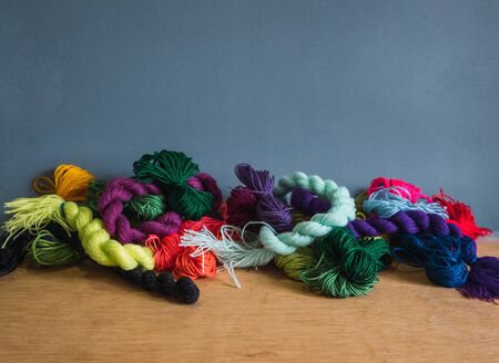 embroidery materials on wooden table and grey background