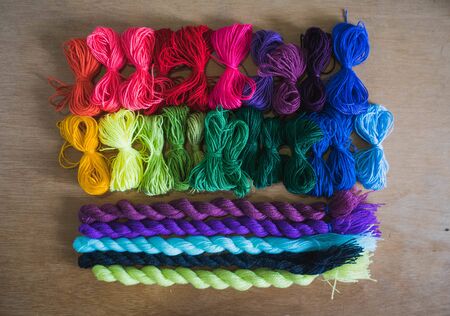 embroidery materials on wooden table and grey background