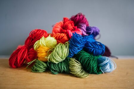 embroidery materials on wooden table and grey background
