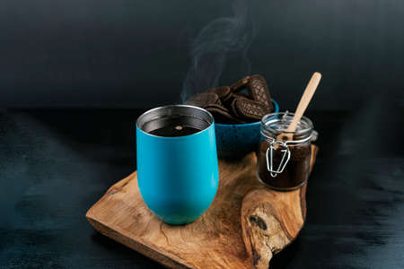 Light blue coffee mug freshly served, with a bowl of chocolate chip cookies on the sideの写真素材