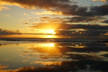 Sunset by the beach and reflection on the waterの写真素材