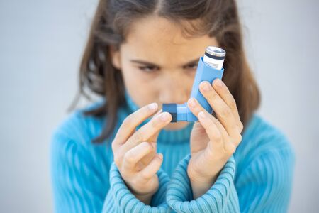 Little girl looking at the inhaler