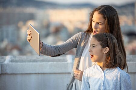 Two excited girls watching multimedia content using a tabletの写真素材