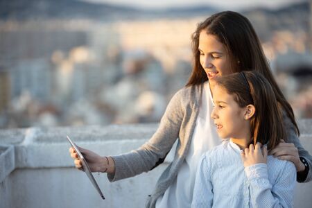 Two sisters watching multimedia content using a tabletの写真素材