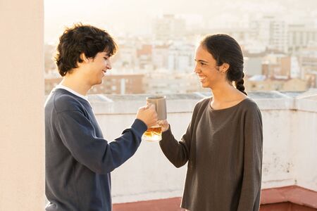 Sister and brother toasting on the terrace