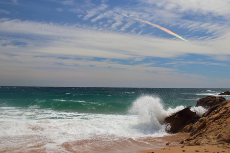 Right side view of Castell beach with rainbow clouds on background, one of the most amazing virgin spots of la Costa Brava seaside, PalamÃ³s, Girona, Catalonia, Spain.の写真素材