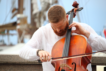 City Hall pier, Oslo, Norway - July, 31st of 2018: Local street musicians play for cash while visitors wait for ferry transport to Bygdoy Peninsula, home of the Norwegian Folk/Flam and Viking Museums.のeditorial素材