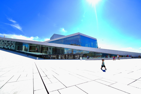 Cheerful little boy runs in front of the Oslo opera building during a sunny summer morning, Oslo, Norway.のeditorial素材