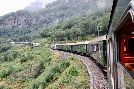 Famous Norwegian Flamsbana train going uphill on its way to Myrdal station and crossing with another one going downhill.  This railroad track is said to be one of the most beautiful ones on earth.のeditorial素材