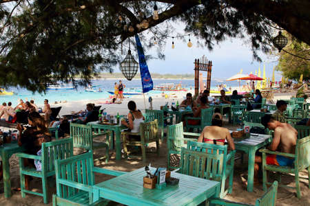 Gili Trawangan, Lombok, Indonesia - August 12th of 2019: Tourists have a meal or take a bath in the amazing spot of the harbor beach of the largest Gili Island.のeditorial素材