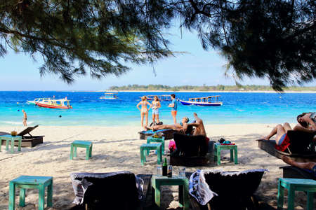 Gili Trawangan, Lombok, Indonesia - August 12th of 2019: Tourists have a meal or take a bath in the amazing spot of the harbor beach of the largest Gili Island.のeditorial素材