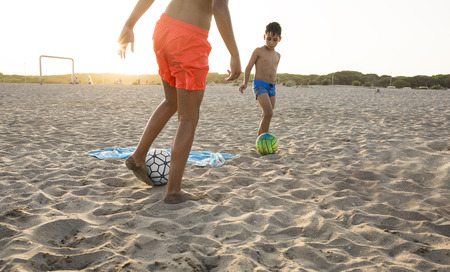 Boy playing football  on the beachの写真素材