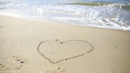 Love heart sign draw on the sand beachの写真素材