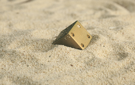 some dices  buried in the sand dunesの写真素材