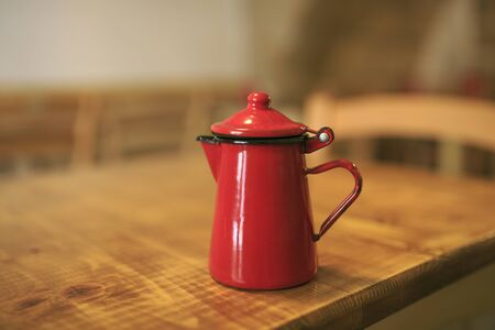 Red vintage teapot on a wooden tableの写真素材