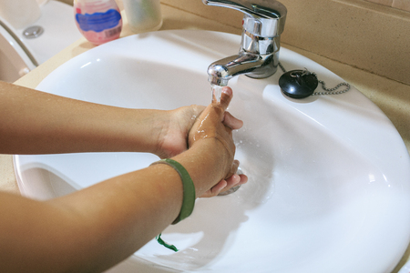 boy cleaning his hands with waterの写真素材