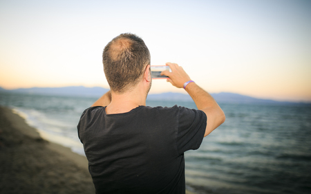 man making a photo on the beachの写真素材