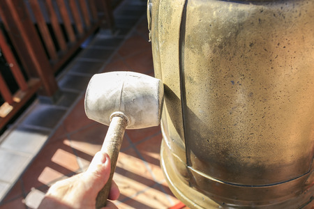 Hand with a hammer with a bellの写真素材