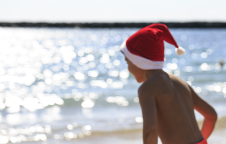 Boy  with Santa hat on the beachの写真素材