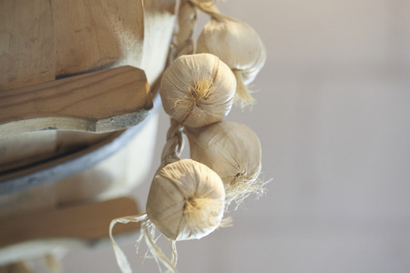 Garlic and onions hanging in the kitchenの写真素材