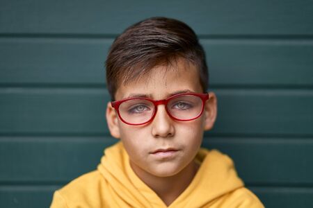 Green eyes kid with red glasses portraitの写真素材