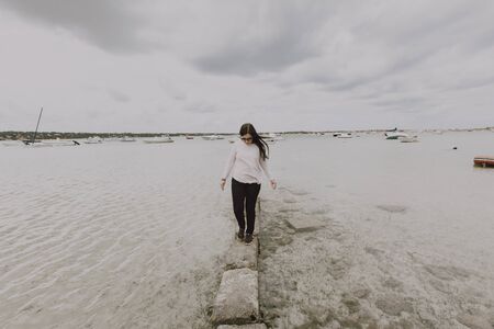 Dressed woman taking a walk on the beachの写真素材