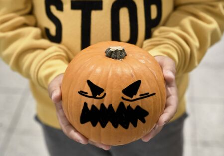 Kid with pumpkin in his handsの写真素材