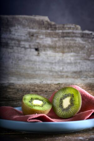 Kiwi cut in two halfs in a wooden tableの写真素材