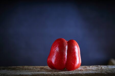 Red sweet pepper in a wooden table . Healthy food