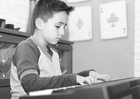 little boy playing classical piano in the living room at homeの写真素材
