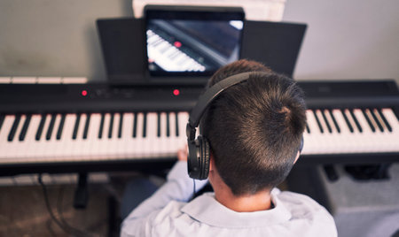 Child learning online piano lessons in quarantine. covid -19の写真素材