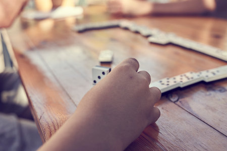 A family playing domino game in a wooden table
