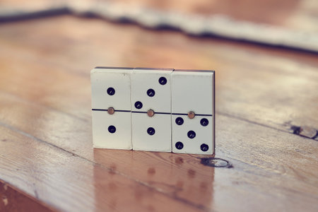 A family playing domino game in a wooden table