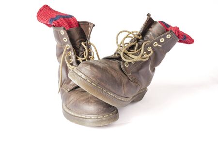 Vintage brown boots with red socks on a white background