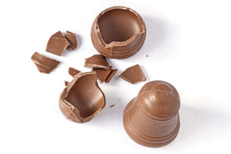 Cracked chocolate bell with another good isolated on whiteの写真素材